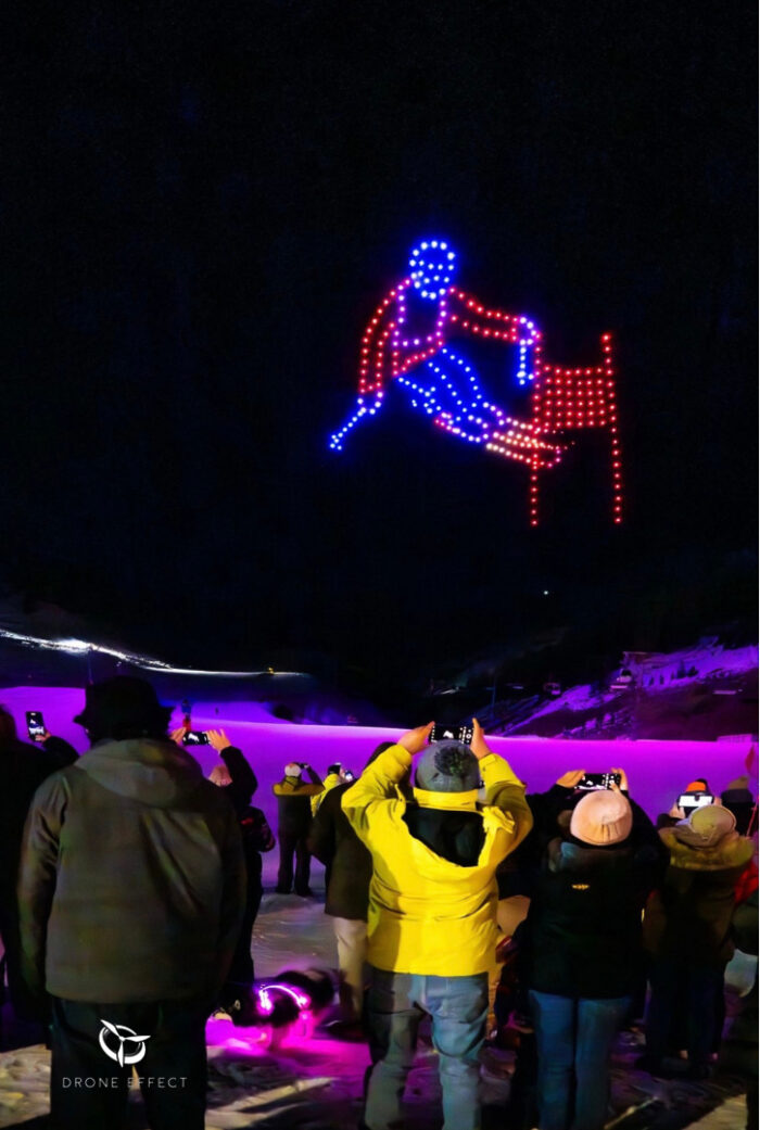 Spectacle de drones lors d’un événement sportif – skieur en slalom avec public émerveillé au premier plan